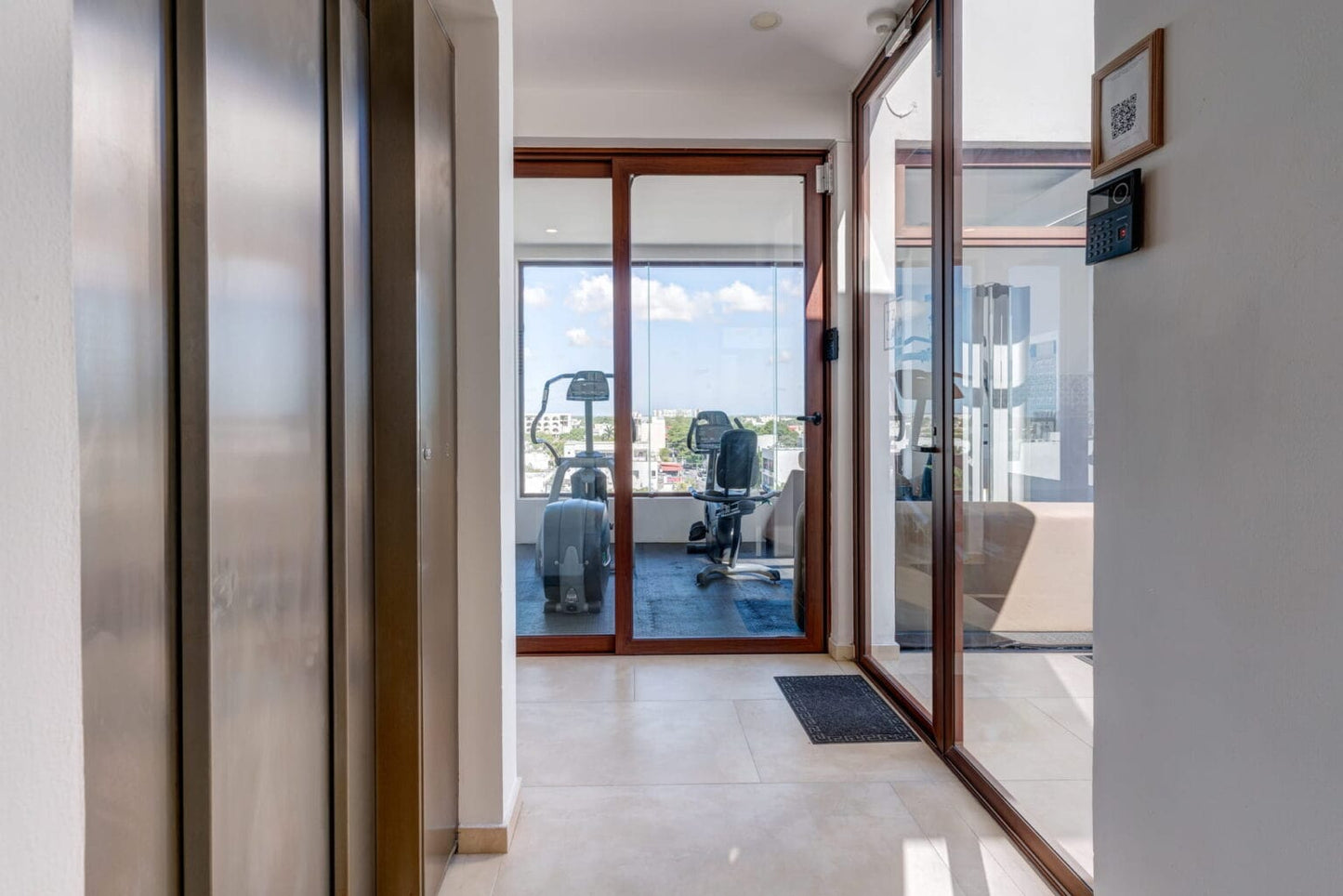un elevador y un gimnasio al fondo en tzalam residences playa del carmen
