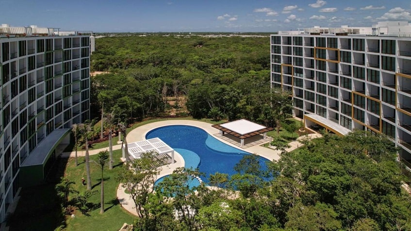 una alberca y areas verdes alrededor en bosques de ciudad mayakoba