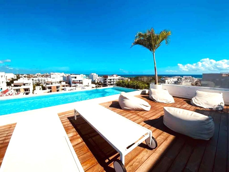 una terraza con camastros en agama beach condo