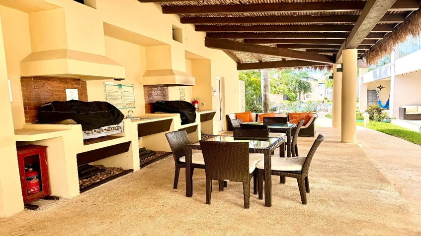 una mesa, un area lounge y asadores en marina mia puerto aventuras