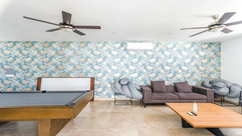 una sala de juegos con un sofa y 2 ventiladores en ipana condos playa del carmen