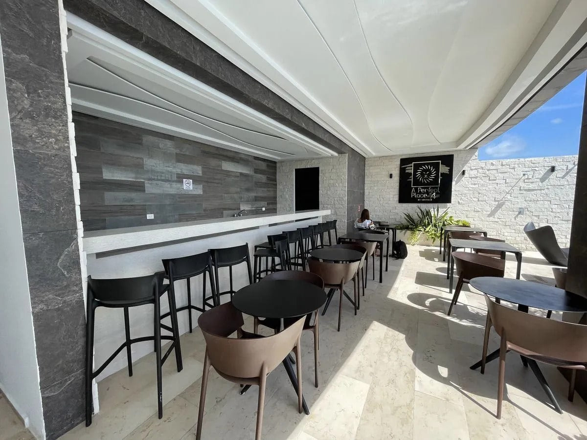 un area lounge con un bar en a perfect place playa del carmen