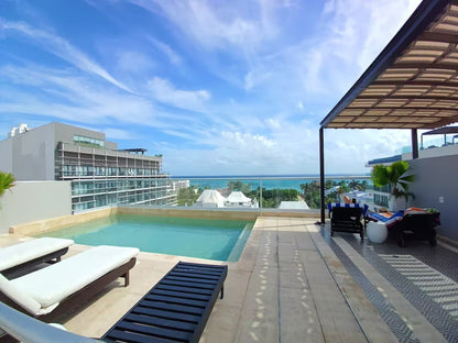 una terraza y una alberca con vista al mar en menesse on the beach playa del carmen