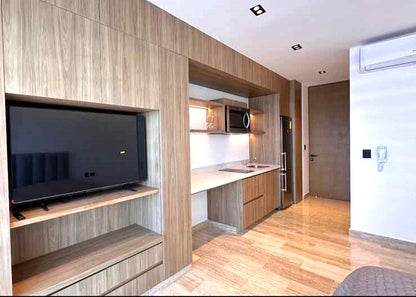 una television y closets de madera en agama beach condos