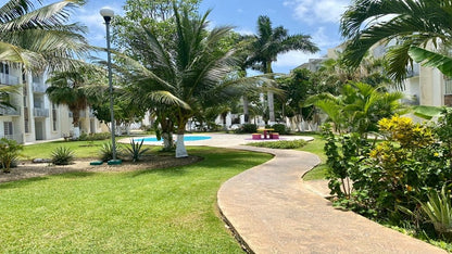 un sendero con areas verdes  en paseo los olivos playa del carmen