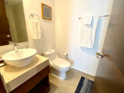 un baño completo con un excusado en tzalam residences playa del carmen