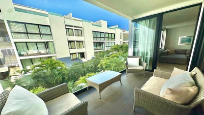 un balcon con 3 sillas y una mesa de centro con vista al exterior en anah condos playa del carmen