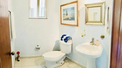 un baño con un cuadro decorativo en condo margaritas playa del carmen