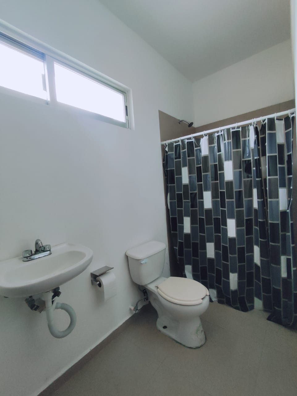 un baño con un lavamanos y un excusado en residencial playa magna playa del carmen