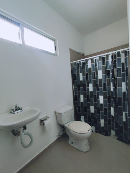 un baño con un lavamanos y un excusado en residencial playa magna playa del carmen