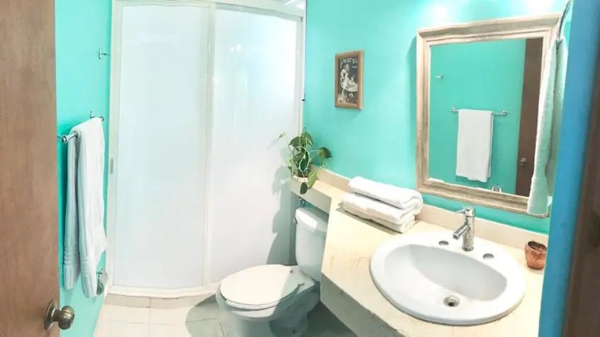 un baño con un lavamanos y un espejo grande en condo margaritas playa del carmen