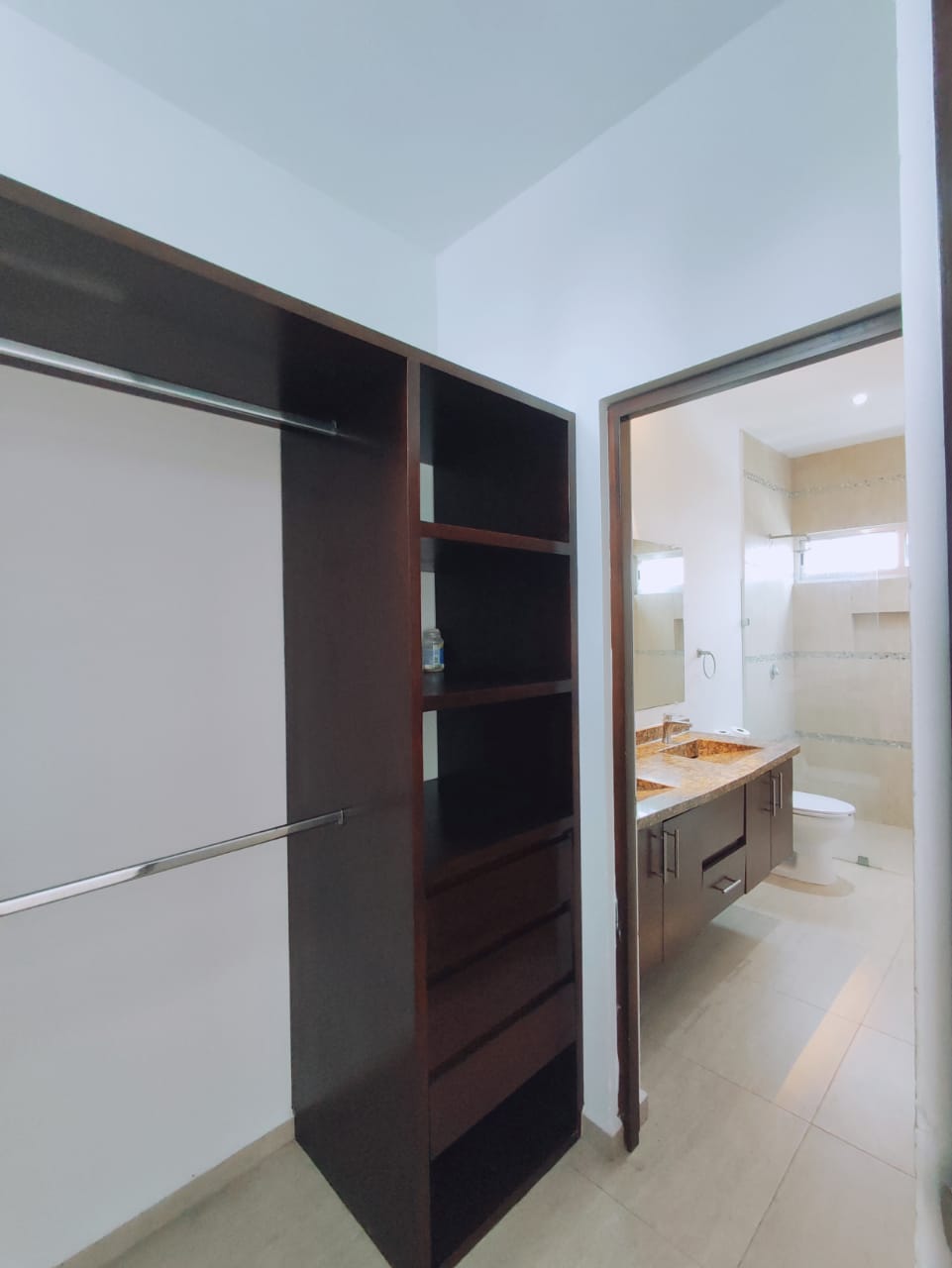 un closet de madera abierto y un baño en residencial playa magna playa del carmen