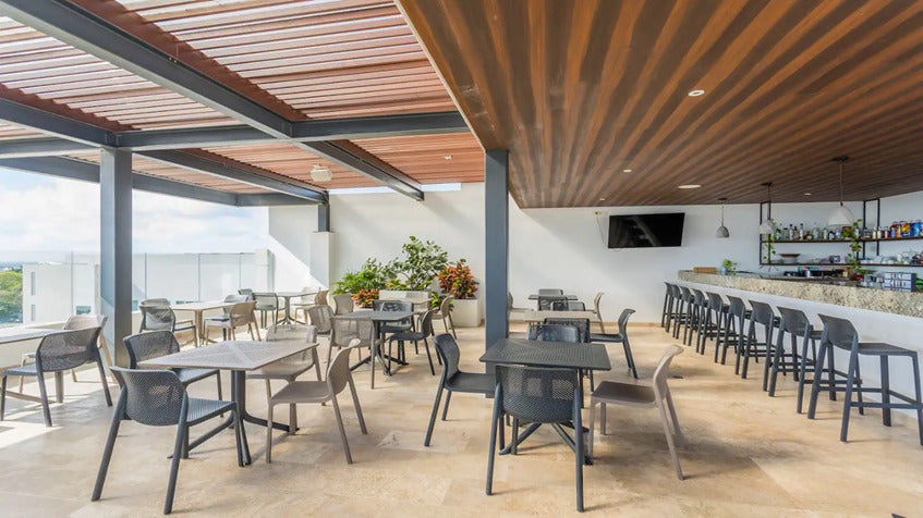 un bar con mesas y sillas en ipana condos playa del carmen