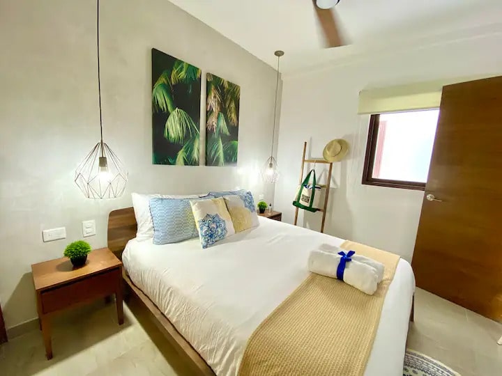 un cama matrimonial, un cuadro decorativos en tzalam residences playa del carmen