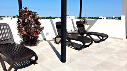 un area de camastros y una terraza en mendaya suites playa del carmen