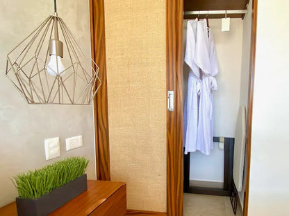 un area de closet con un baño al fondo en tzalam residences playa del carmen