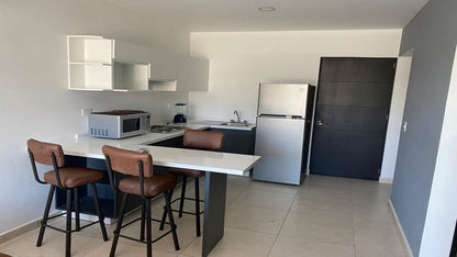 una cocina y una barra desayunadora en edificio ejidal playa del carmen