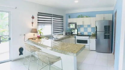 una cocina integral con un refrigerador en condo margaritas playa del carmen