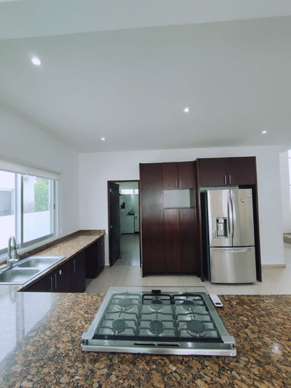 una cocina con una estufa y un refrigerador grande en residencial playa magna playa del carmen