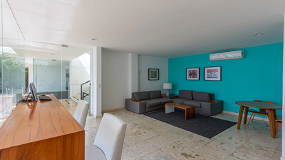 un area de coworking con un sofa y una computadora en anah condos playa del carmen