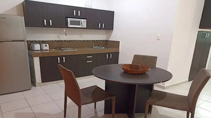 una sala comedor con cocina en xharm condo playa del carmen