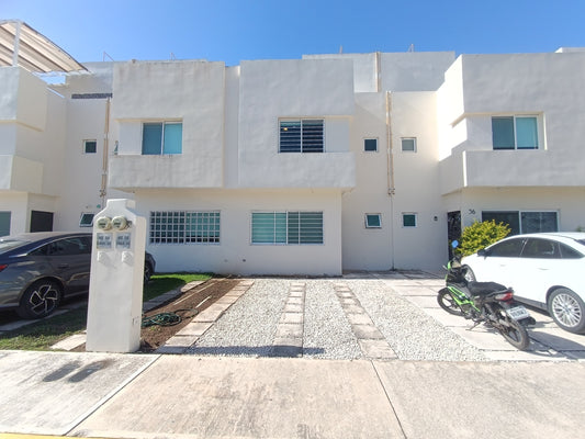 una fachada de una casa de 2 niveles en residencial lunamar playa del carmen