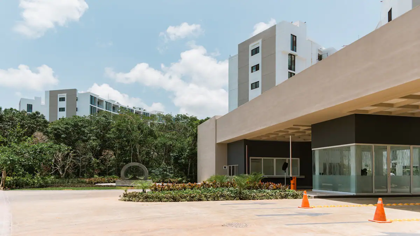 una fachada con una entrada principal en bosques de ciudad mayakoba