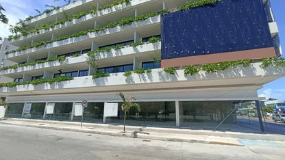 una fachada exterior de un edificio con locales comerciales en renta en sensai playa del carmen