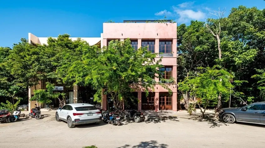 una fachada con locales comerciales y estacionamiento en anemona tulum