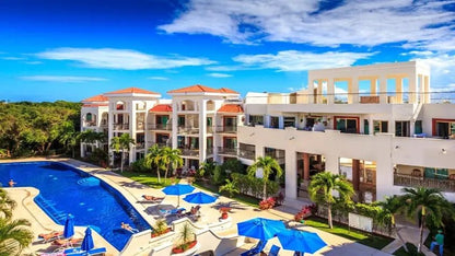 fachada interior con una alberca y departamentos en paseo del sol playa del carmen