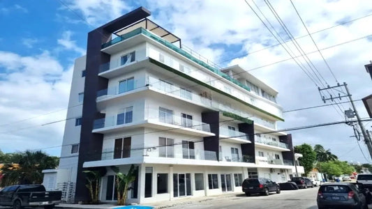 una fachada externa de un edificio de departamentos y locales comerciales en yaakun condos playa del carmen