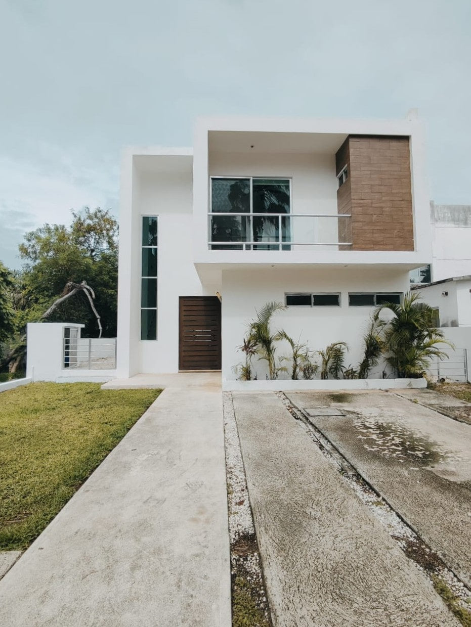 una fachada de una casa de 2 niveles con alberca propia en residencial playa magna playa del carmen
