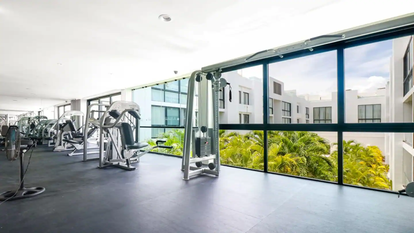 un gimnasio equipado con vista al exterior en anah condos playa del carmen