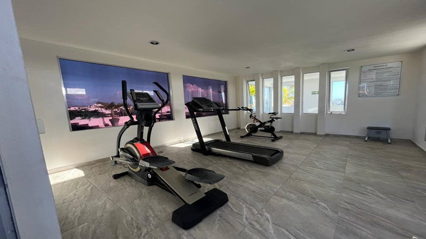 un gimnasio con caminadoras en horizonte 34 playa del carmen