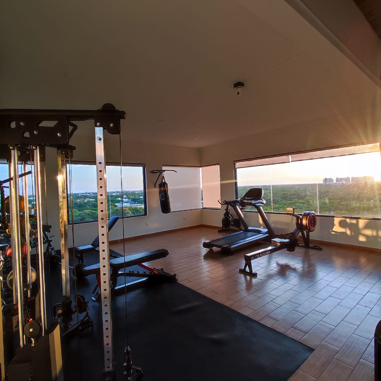 un gimnasio abierto equipado con maquinas y pesas en playa aurora playa del carmen