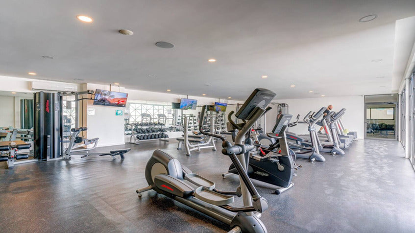 un gimnasio equipado con caminadoras en ipana condos playa del carmen