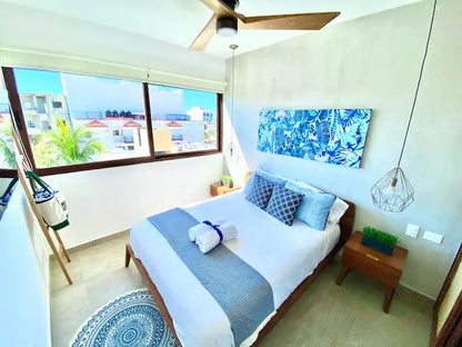 una recamara con un ventilador en tzalam residences playa del carmen