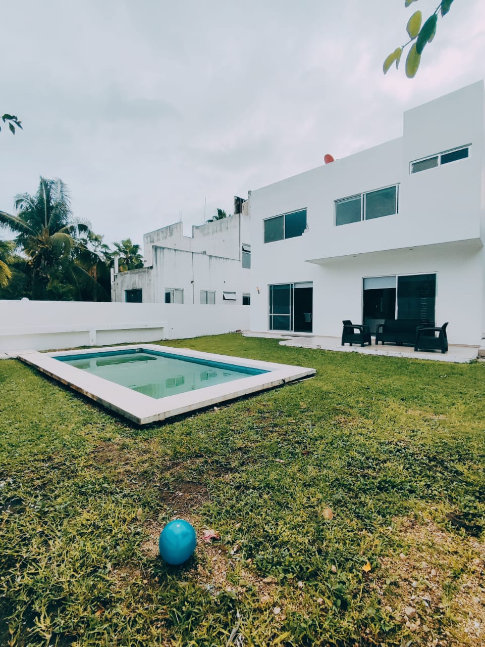una piscina grande, una pelota y un comedor en la terraza en residencial playa magna playa del carmen