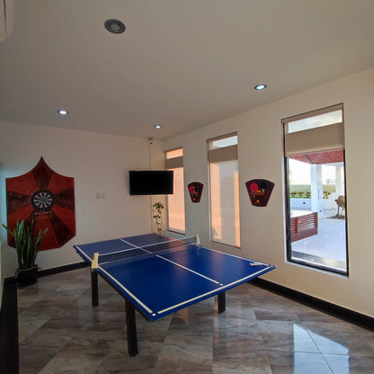 una sala de juegos con una mesa de ping pong en playa aurora playa del carmen