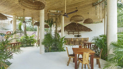 una palapa con un bar y mesas en muuk tulum