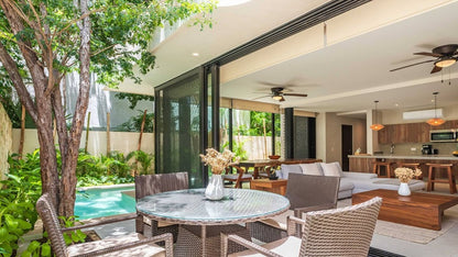 un patio con jardin exterior y una sala en mak tulum