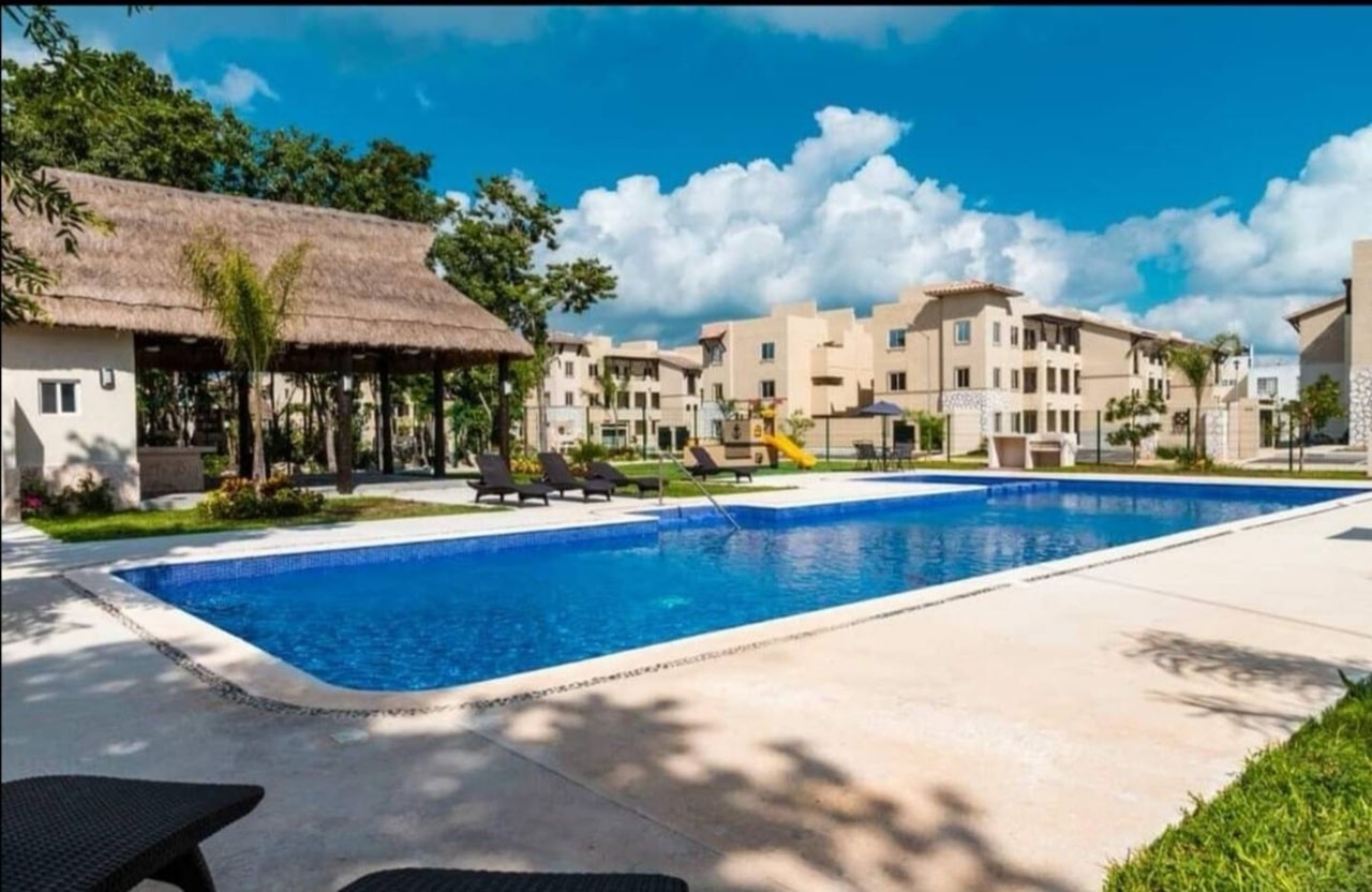 una piscina con una casa club en real amalfi plaua de carmen
