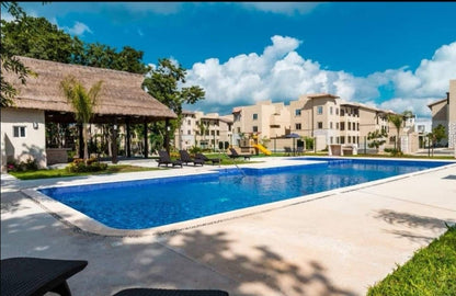 una piscina con una casa club en real amalfi plaua de carmen