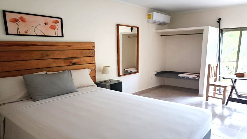 una recamara con cama matrimonial y un cuadro decorativo en siena suites playa del carmen