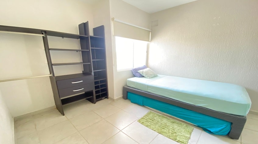 una recamara con closets abiertos y una cama matrimonial  en paseo los olivos playa del carmen