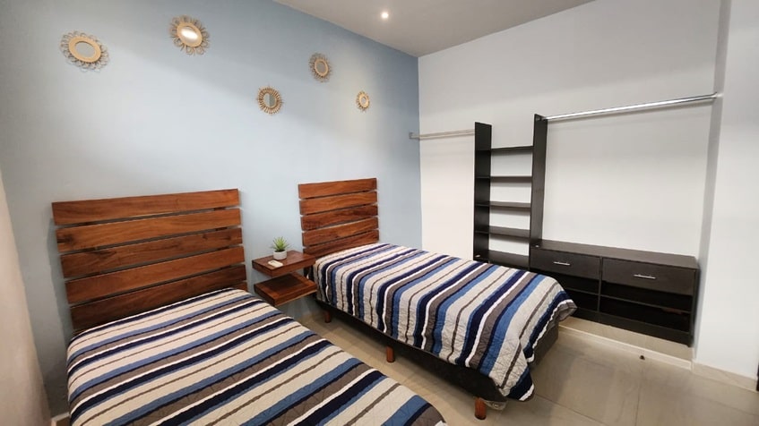 una recamara con 2 camas individuales y un closet en selvanova coto 8 playa del carmen