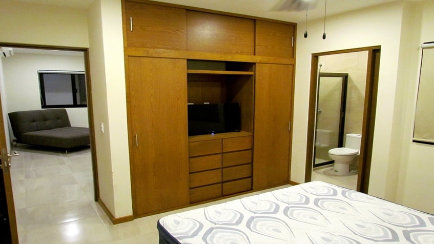 una recamara con un closet de madera en mendaya suites playa del carmen