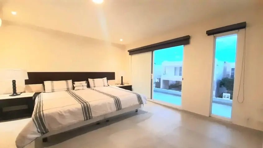 una cama queen size con vista al exterior en selvanova playa del carmen