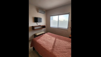 una recamara con una tv y un aire acondicionado en selvanova coto 8 playa del carmen