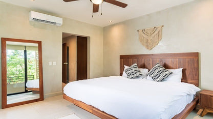 una cama king size, un ventilador y un aire acondicionado en mak tulum